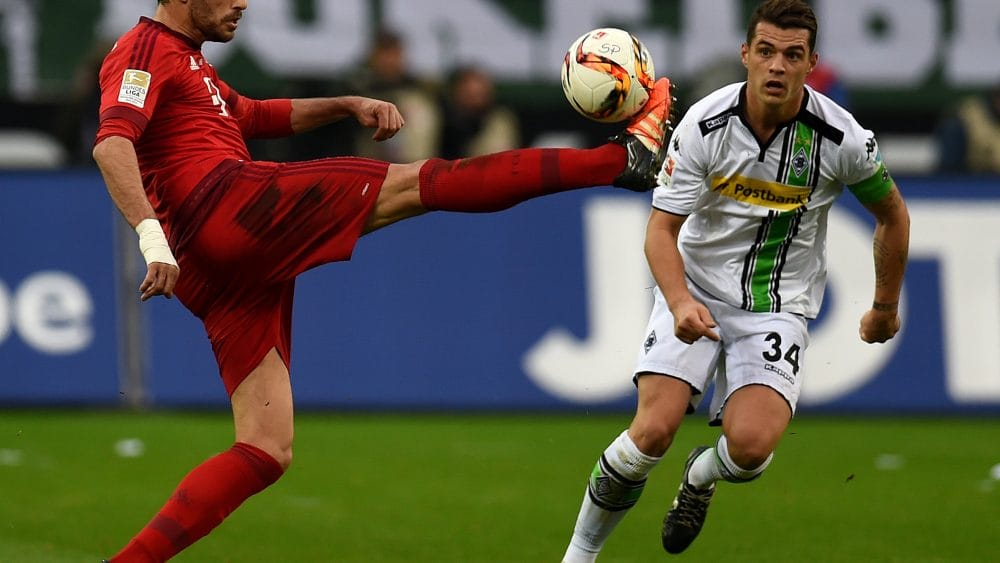 Bayern Munich's Spanish midfielder Javier Martinez (L) and Moenchengladbach's Swiss midfielder Granit Xhaka vie for the ball during the German first division Bundesliga football match Moenchengladbach vs Bayern Munich in Moenchengladbach on December 5, 2015. AFP PHOTO / PATRIK STOLLARZ