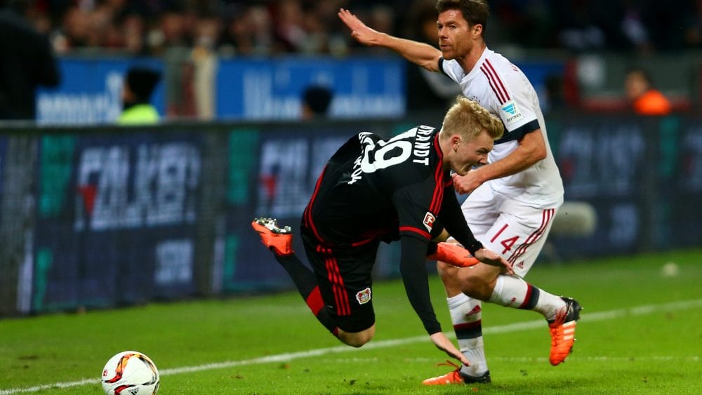 LEVERKUSEN, GERMANY - FEBRUARY 06: Xabi Alonso of FC Bayern Muenchen challenges Julian Brandt of Bayer Leverkusen during the Bundesliga match between Bayer Leverkusen and FC Bayern Muenchen at BayArena on February 6, 2016 in Leverkusen, Germany. (Photo by Alex Grimm/Bongarts/Getty Images)