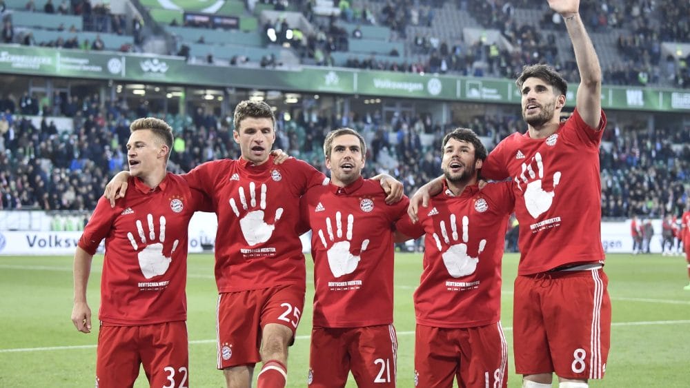 Bayern's team celebrates becoming the new German champion after the German first division Bundesliga football match between VfL Wolfsburg and Bayern Munich on April 29, 2017 in Wolfsburg, northern Germany. Bayern Munich won a fifth consecutive German league title. / AFP PHOTO / John MACDOUGALL / RESTRICTIONS: DURING MATCH TIME: DFL RULES TO LIMIT THE ONLINE USAGE TO 15 PICTURES PER MATCH AND FORBID IMAGE SEQUENCES TO SIMULATE VIDEO. == RESTRICTED TO EDITORIAL USE == FOR FURTHER QUERIES PLEASE CONTACT DFL DIRECTLY AT + 49 69 650050 (Photo credit should read JOHN MACDOUGALL/AFP/Getty Images)