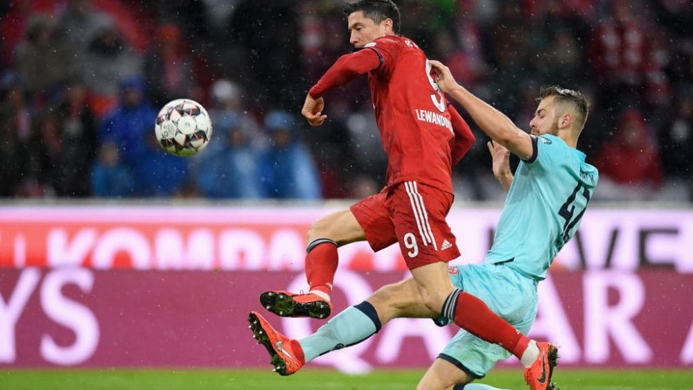 Robert Lewandowski of FC Bayern München challenges Alexander Hack of 1.FSV Mainz 05 during the Bundesliga match between FC Bayern Muenchen and 1. FSV Mainz 05 at Allianz Arena on March 17, 2019 in Munich, Germany. (Photo by Christian Kaspar-Bartke/Bongarts/Getty Images)