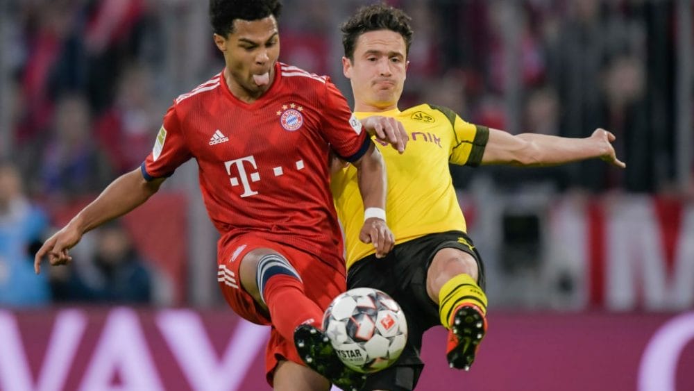 Bayern Munich's German midfielder Serge Gnabry and Dortmund's Danish midfielder Thomas Delaney vie for the ball during the German first division Bundesliga football match between FC Bayern Munich and BVB Borussia Dortmund in Munich, southern Germany, on April 6, 2019. (Photo by Guenter SCHIFFMANN / AFP)