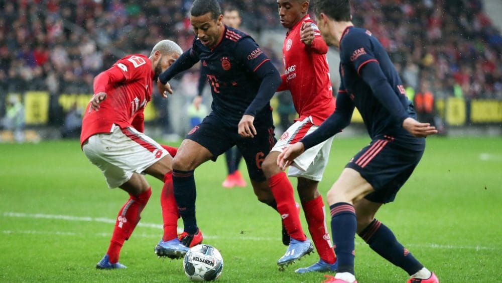 MAINZ, GERMANY - FEBRUARY 01: Thiago Alcantara of Muenchen eludes Jerry St. Juste (L) and Leandro Barreiro of Mainz on his way to score his team's third goal during the Bundesliga match between 1. FSV Mainz 05 and FC Bayern Muenchen at Opel Arena on February 01, 2020 in Mainz, Germany. (Photo by Alex Grimm/Bongarts/Getty Images)