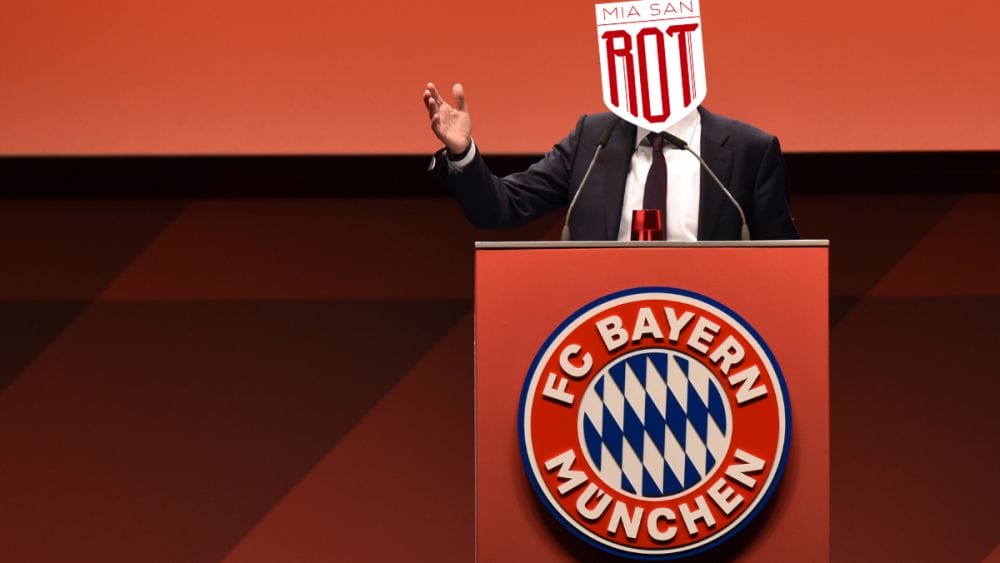 Präsident Herbert Hainer ist bei einer Jahreshauptversammlung hinter einem Podium zu sehen. Auf dem Podium ist ein Bayern-Logo abgebildet, er selbst trägt einen dunklen Anzug, mit hellem Hemd und dunkelroter Krawatte. Über seinen Kopf ist das Miasanrot-Logo rein retuschiert.